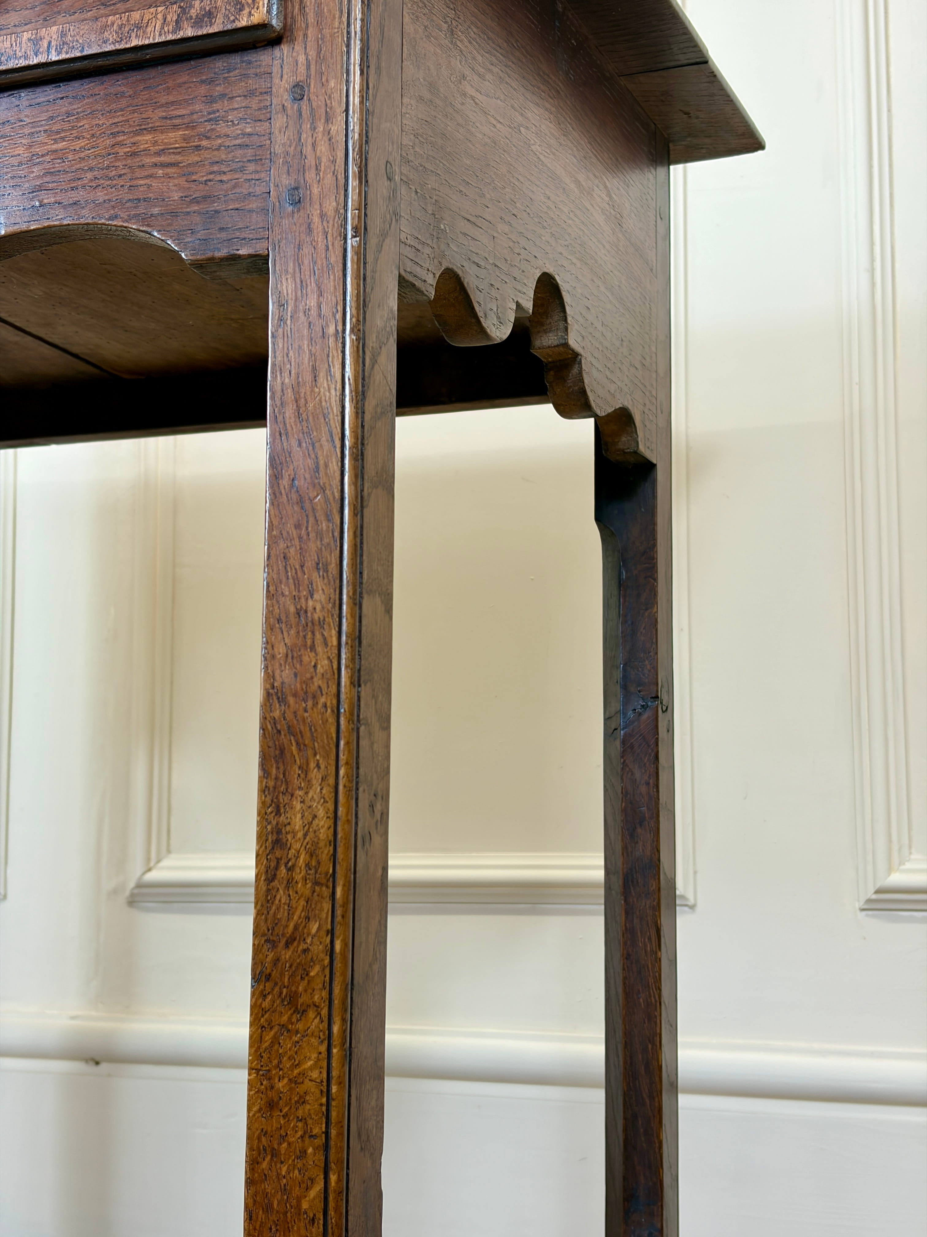 Close-up of a wooden cabinet with intricate carvings against a white paneled wall.
