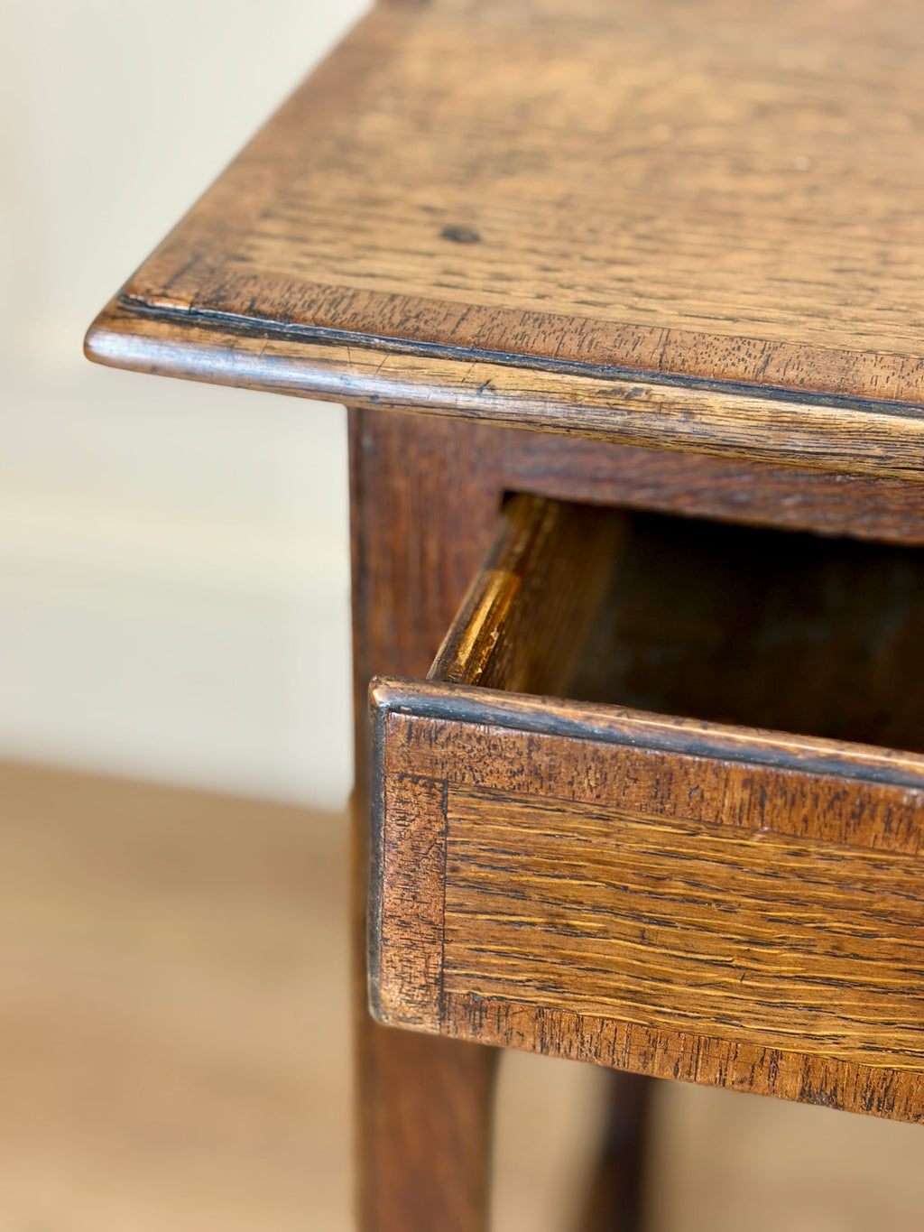 Close-up of a wooden side table with a drawer.