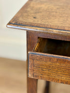 Close-up of a wooden side table with a drawer.