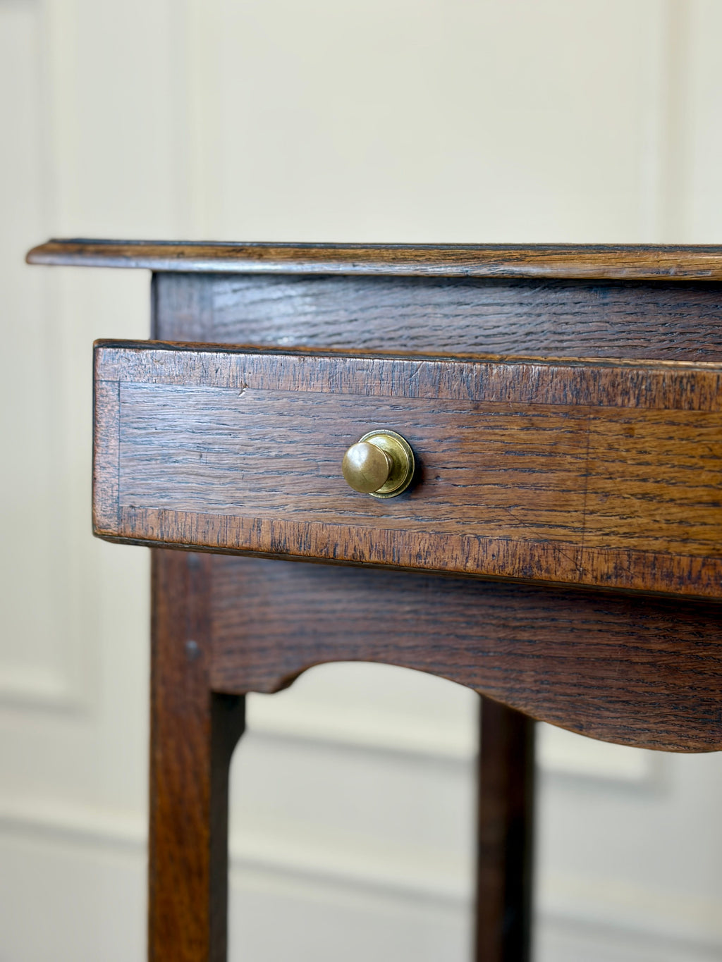 Close-up of a wooden drawer with a brass knob on a white background