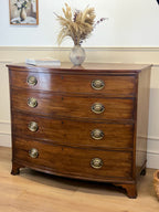 Wooden dresser with brass handles in a room setting