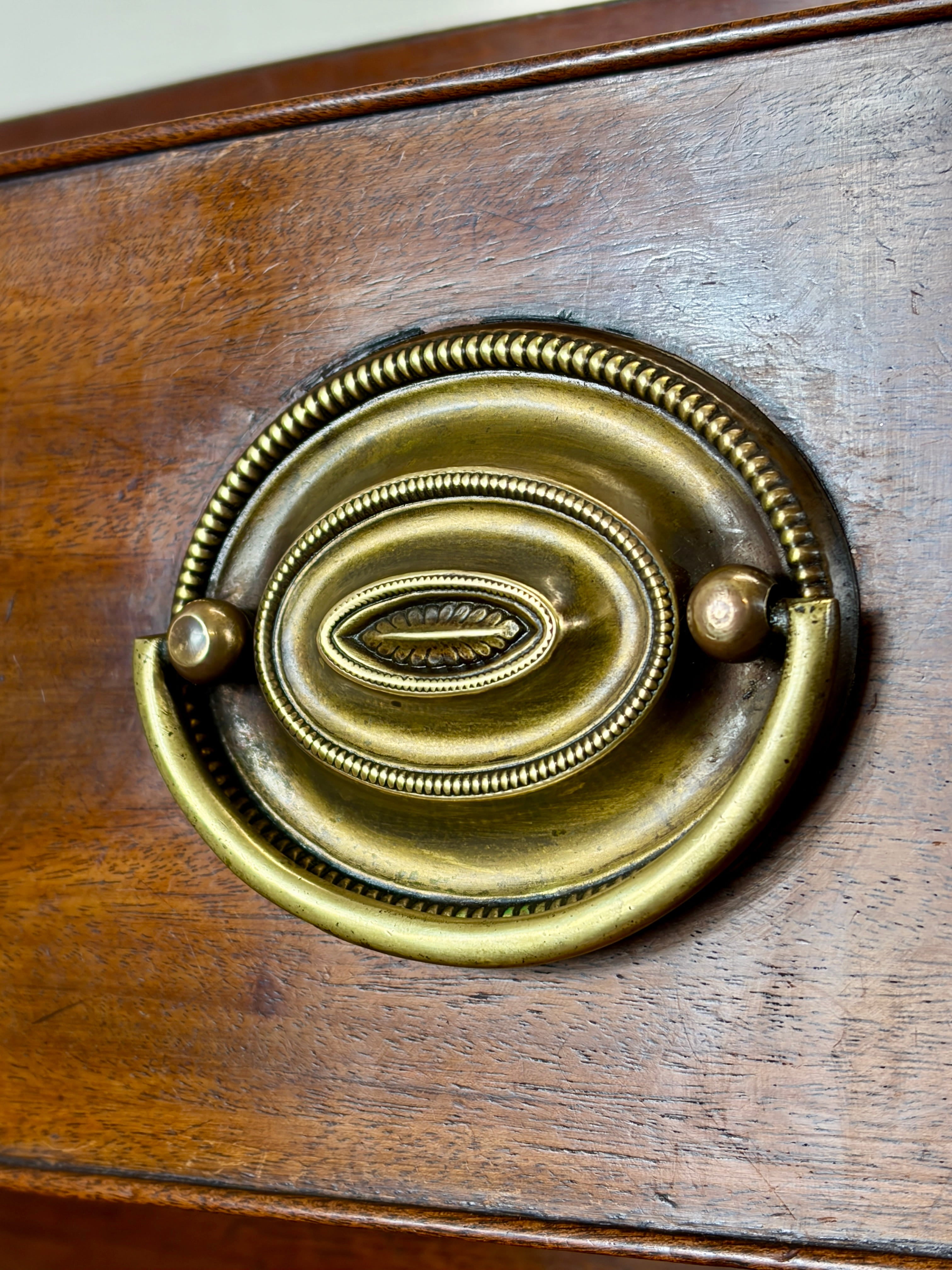 Close-up of a wooden surface with a decorative brass handle