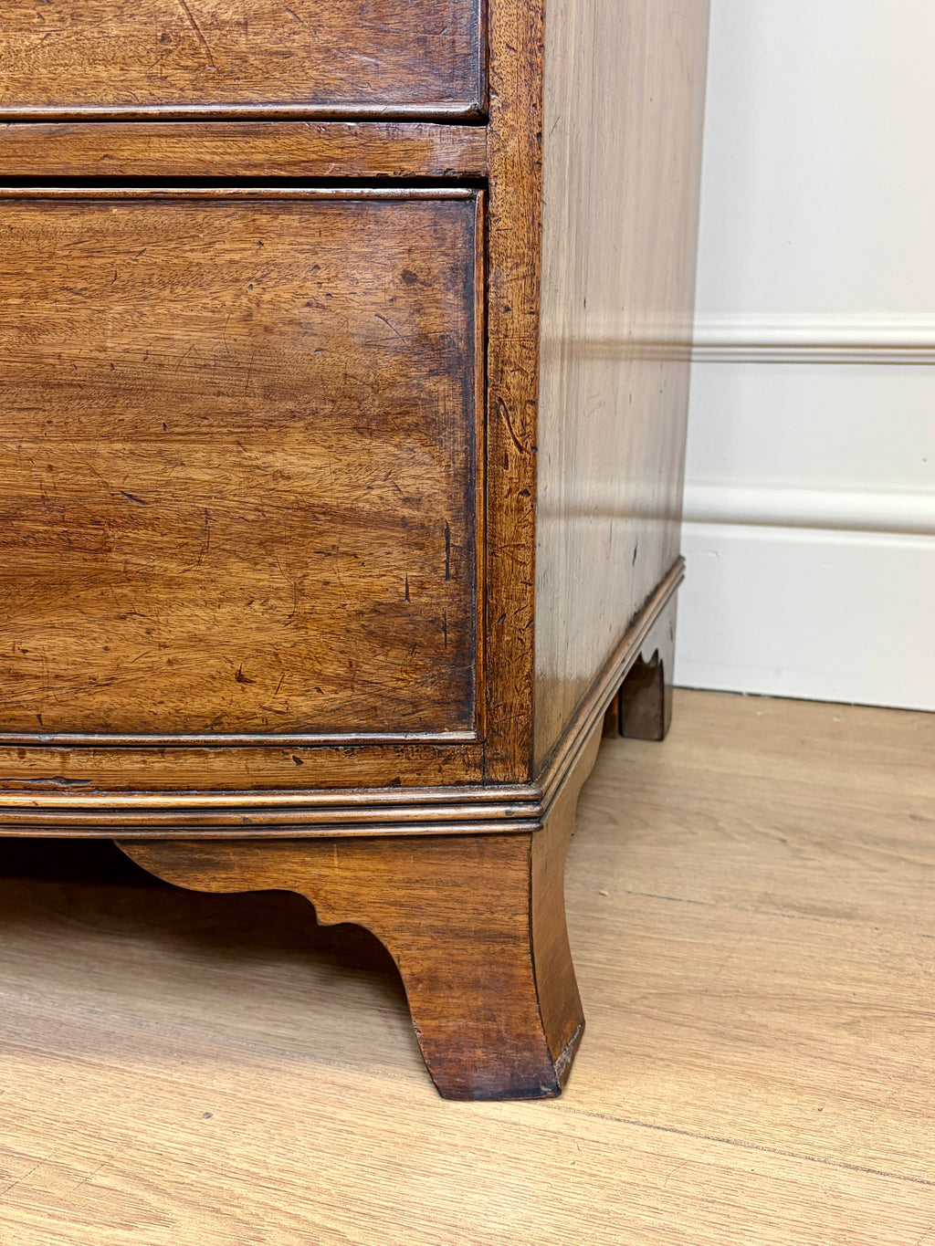 Wooden cabinet corner with a white wall background