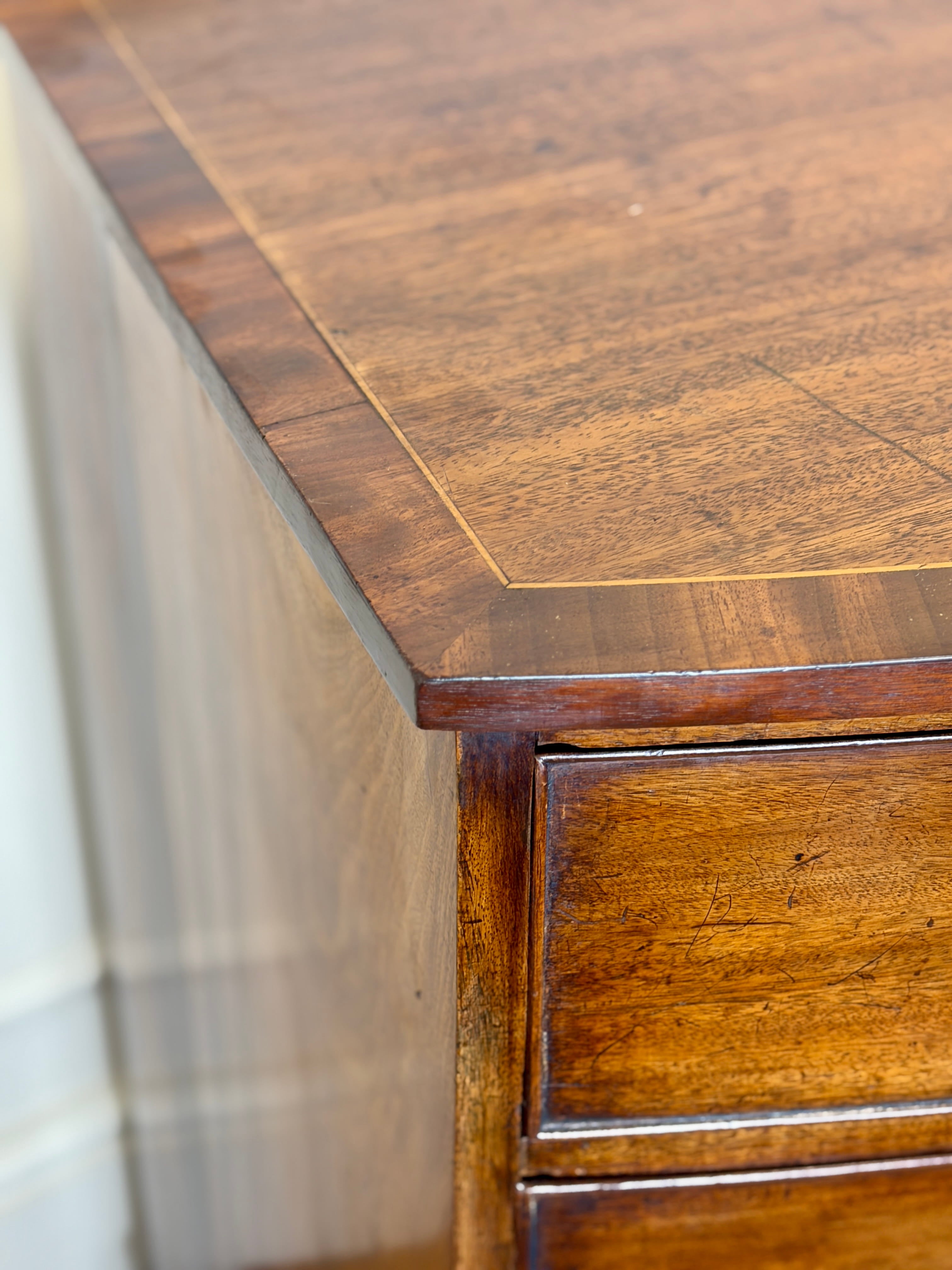Close-up of a wooden desk with a focus on the top and side.