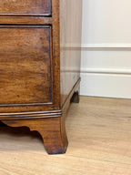 Wooden furniture leg on a wooden floor with a white wall in the background