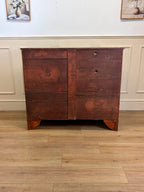 Wooden dresser with two drawers on a wooden floor against a white wall.