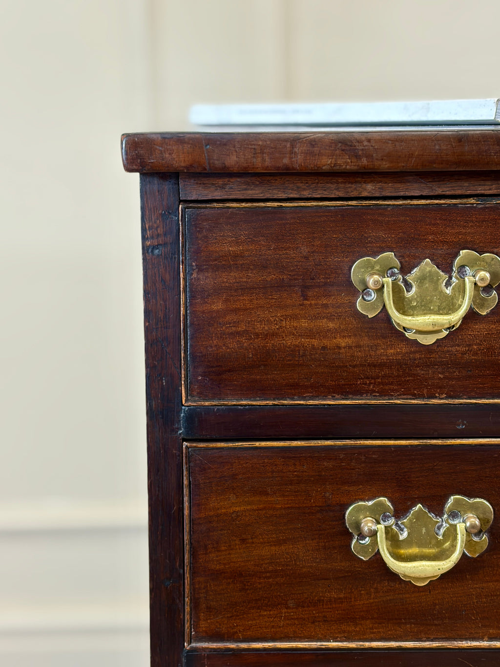 Wooden dresser with brass handles on a neutral background