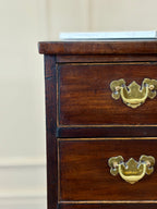Wooden dresser with brass handles on a neutral background