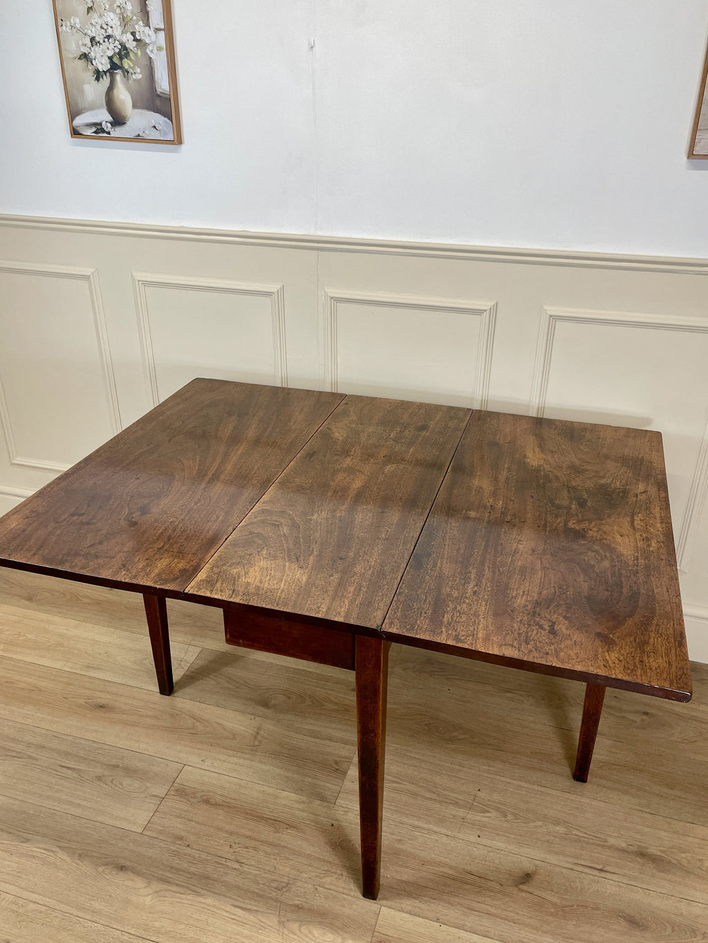 Wooden dining table in a room with light-colored walls and flooring.
