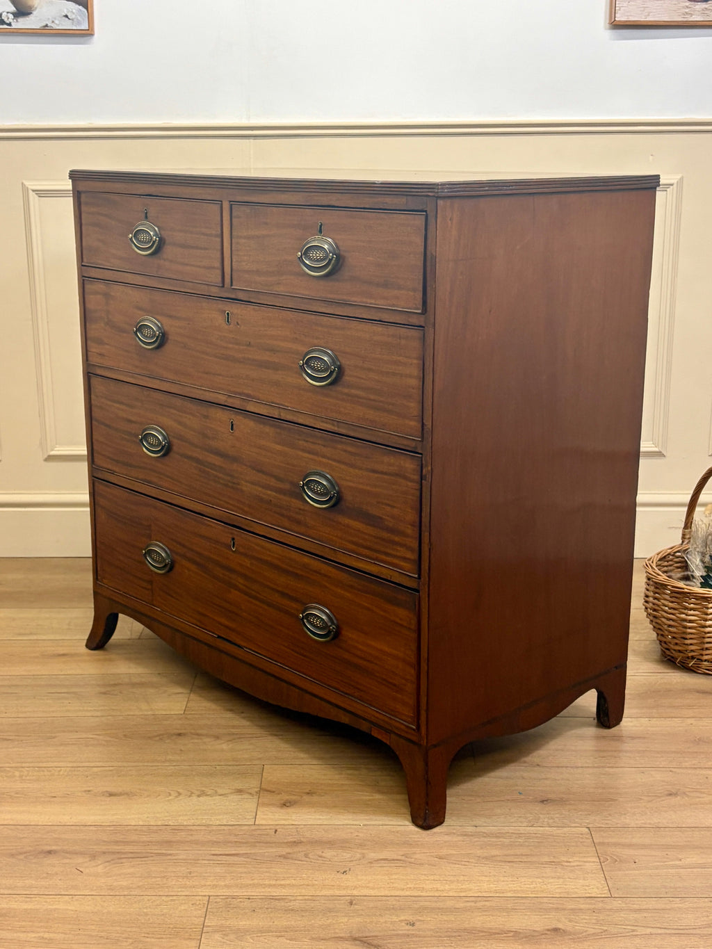 Wooden dresser with four drawers on a wooden floor.