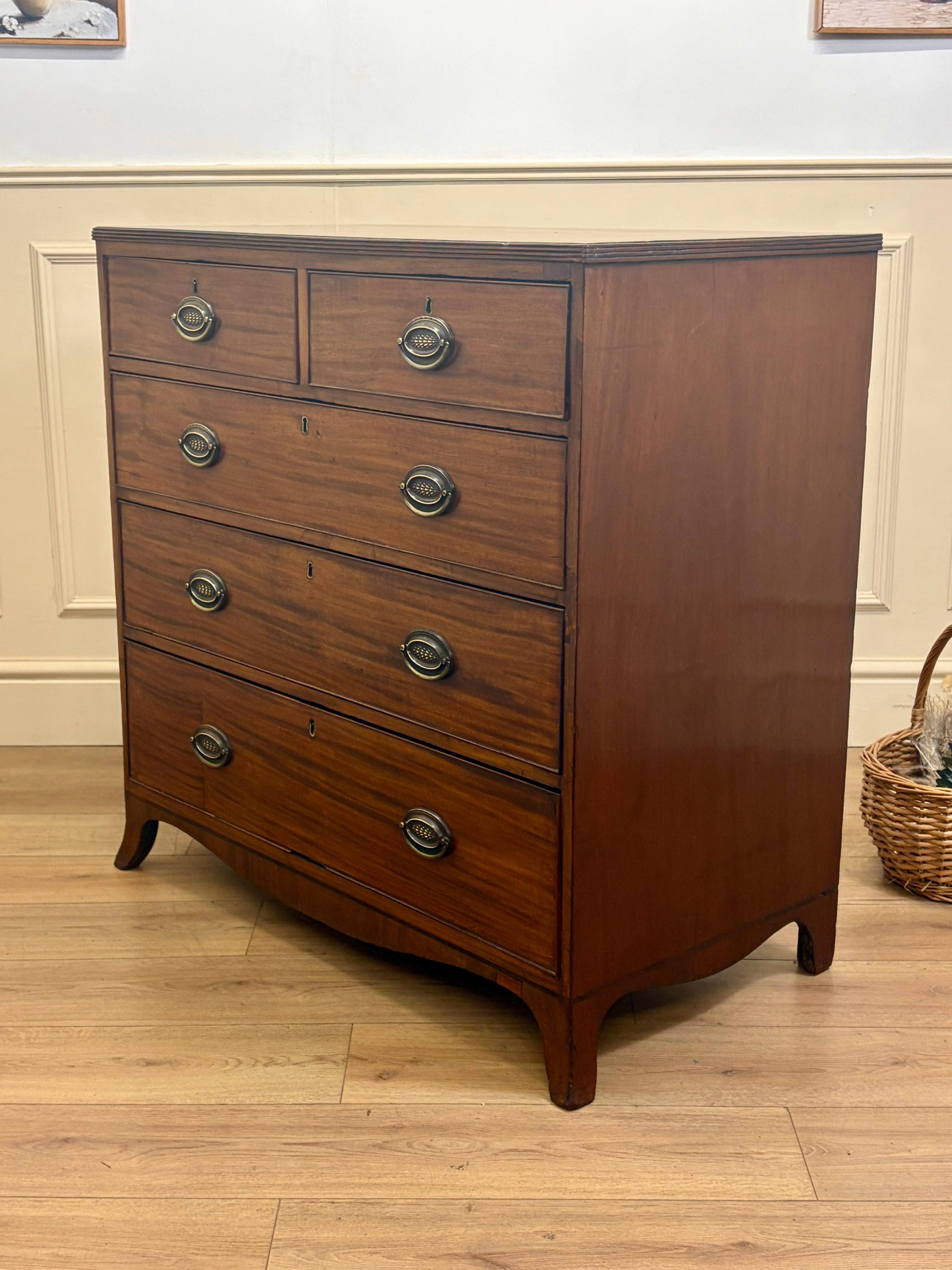 Wooden dresser with four drawers on a wooden floor.