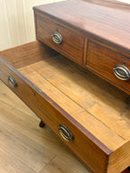 Wooden drawer unit with two visible drawers on a wooden floor.