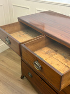 Wooden dresser with open drawers on a wooden floor.