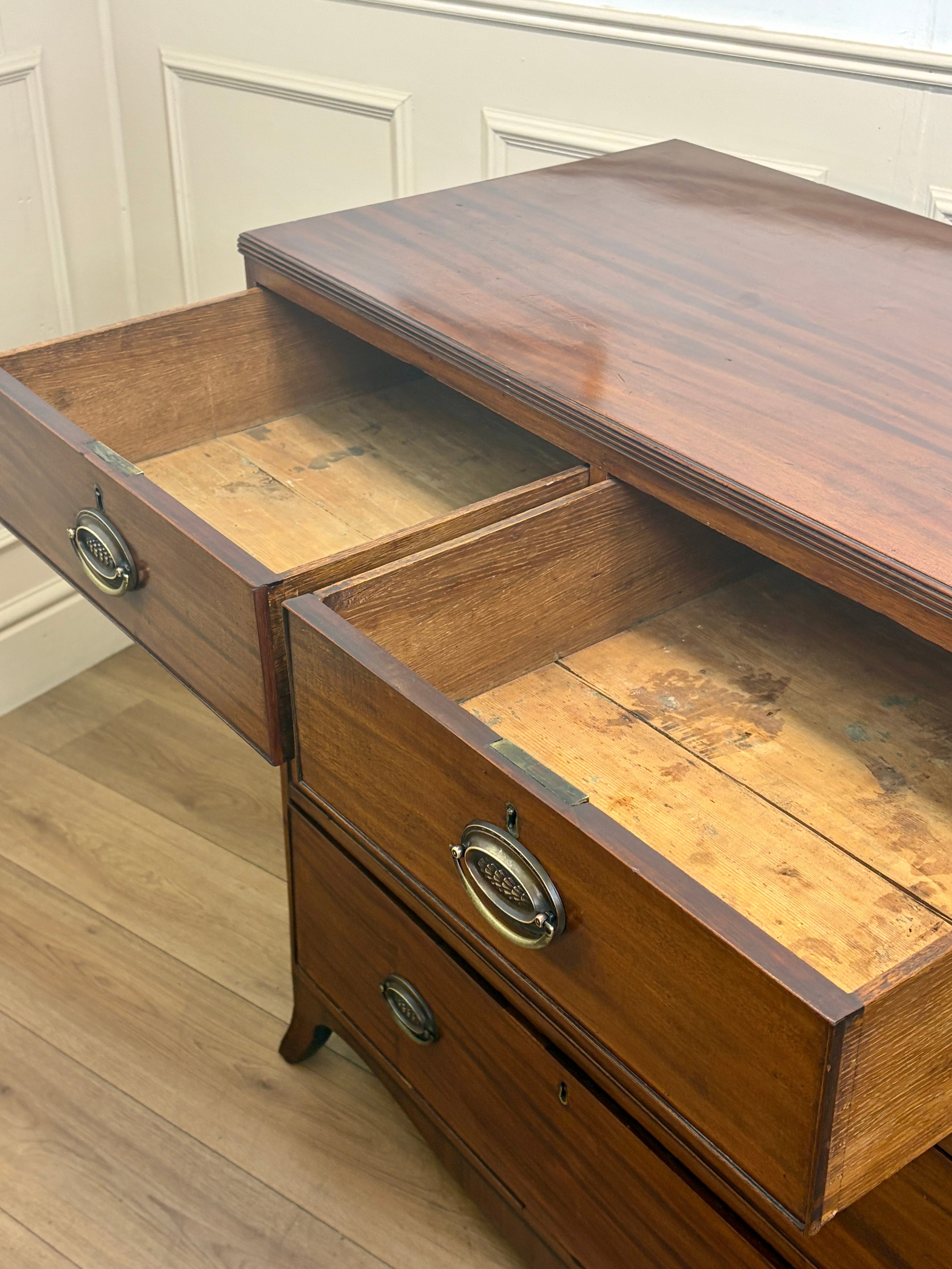 Wooden dresser with open drawers on a wooden floor.