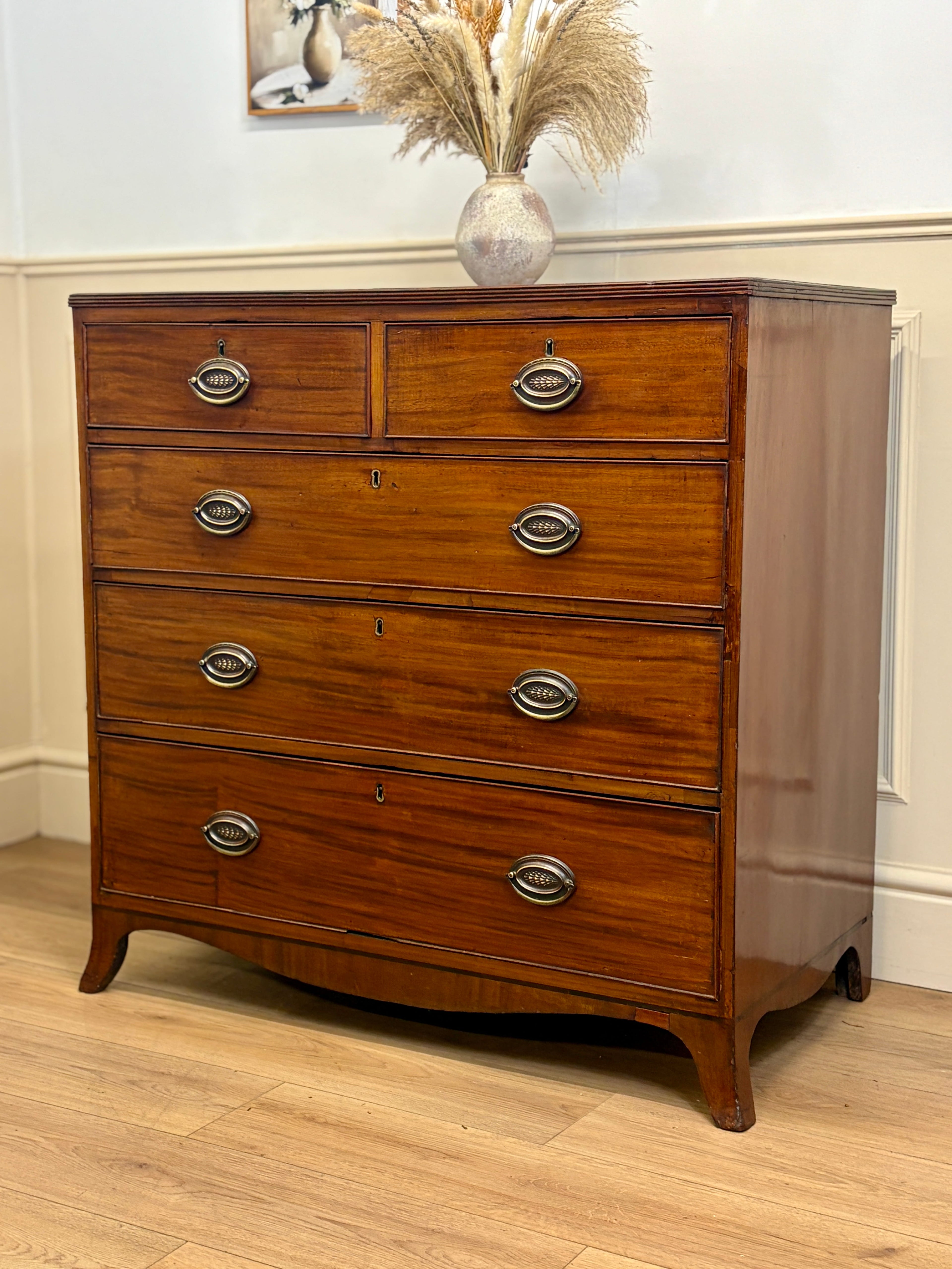 Wooden dresser with silver handles on a wooden floor.