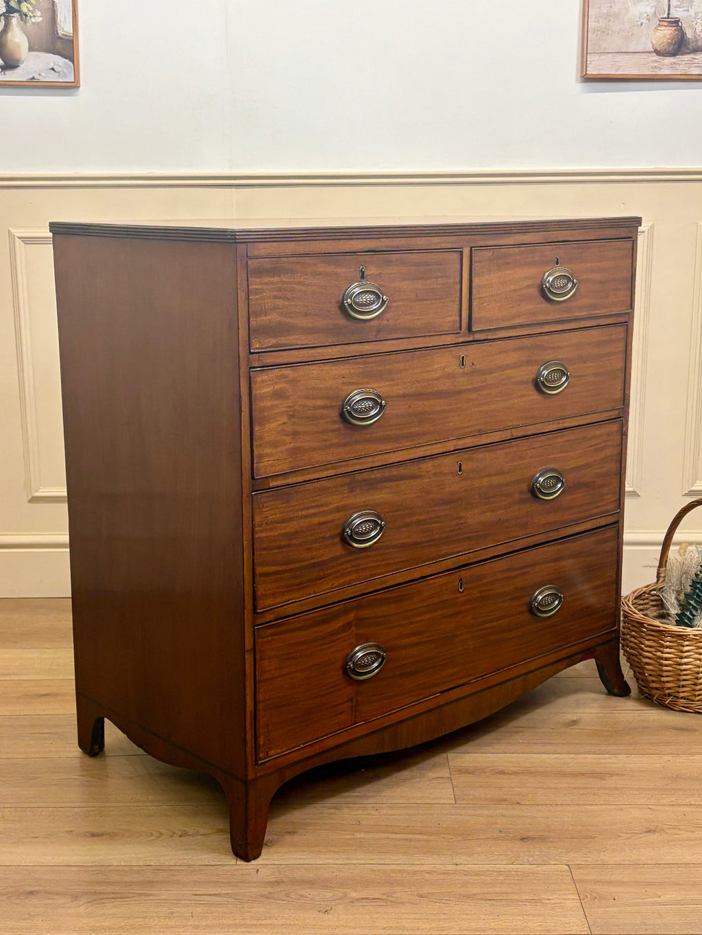 Wooden dresser with four drawers on a wooden floor.