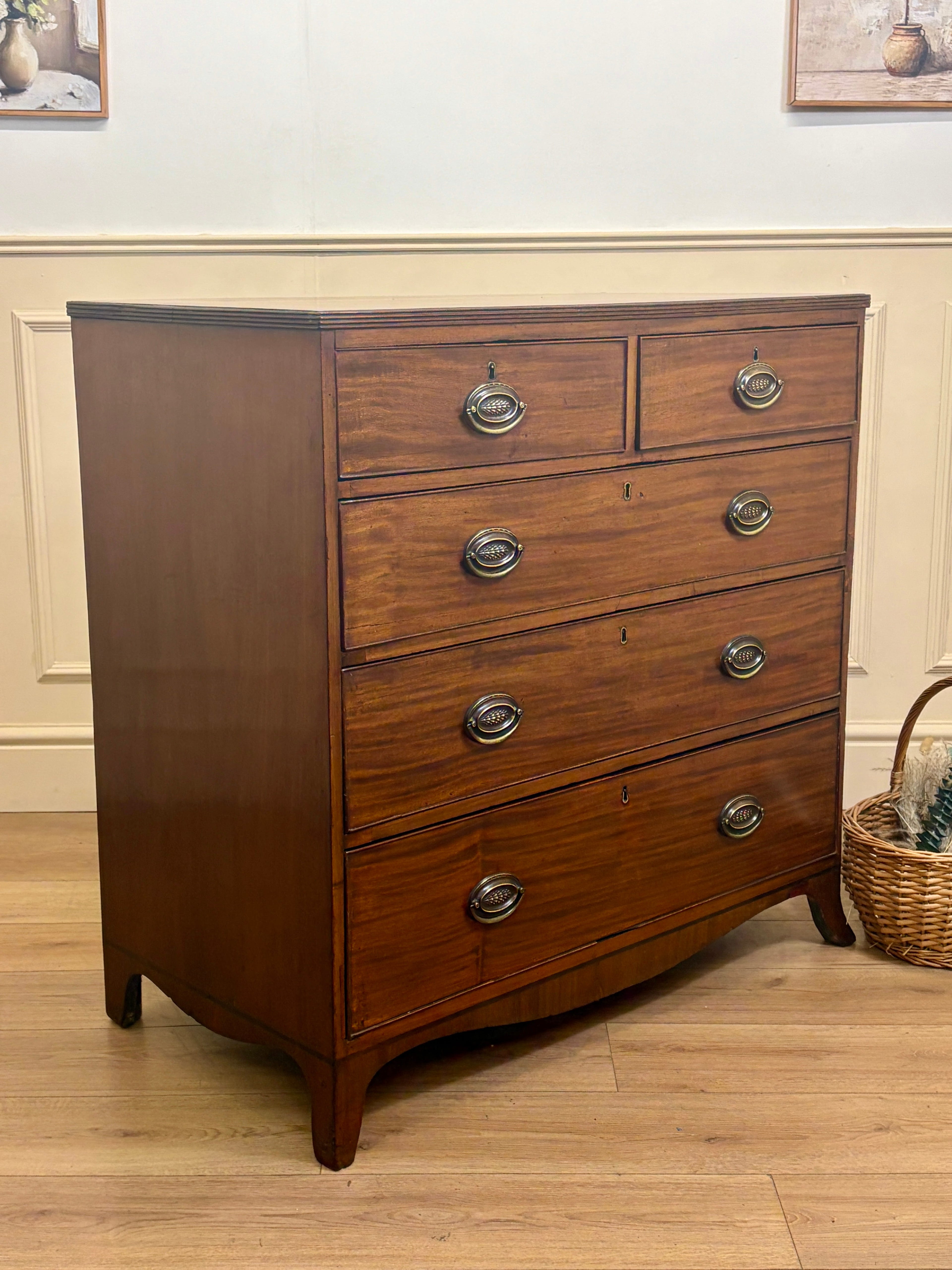 Wooden dresser with four drawers on a wooden floor.