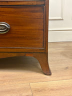 Wooden dresser with a metal handle on a wooden floor.