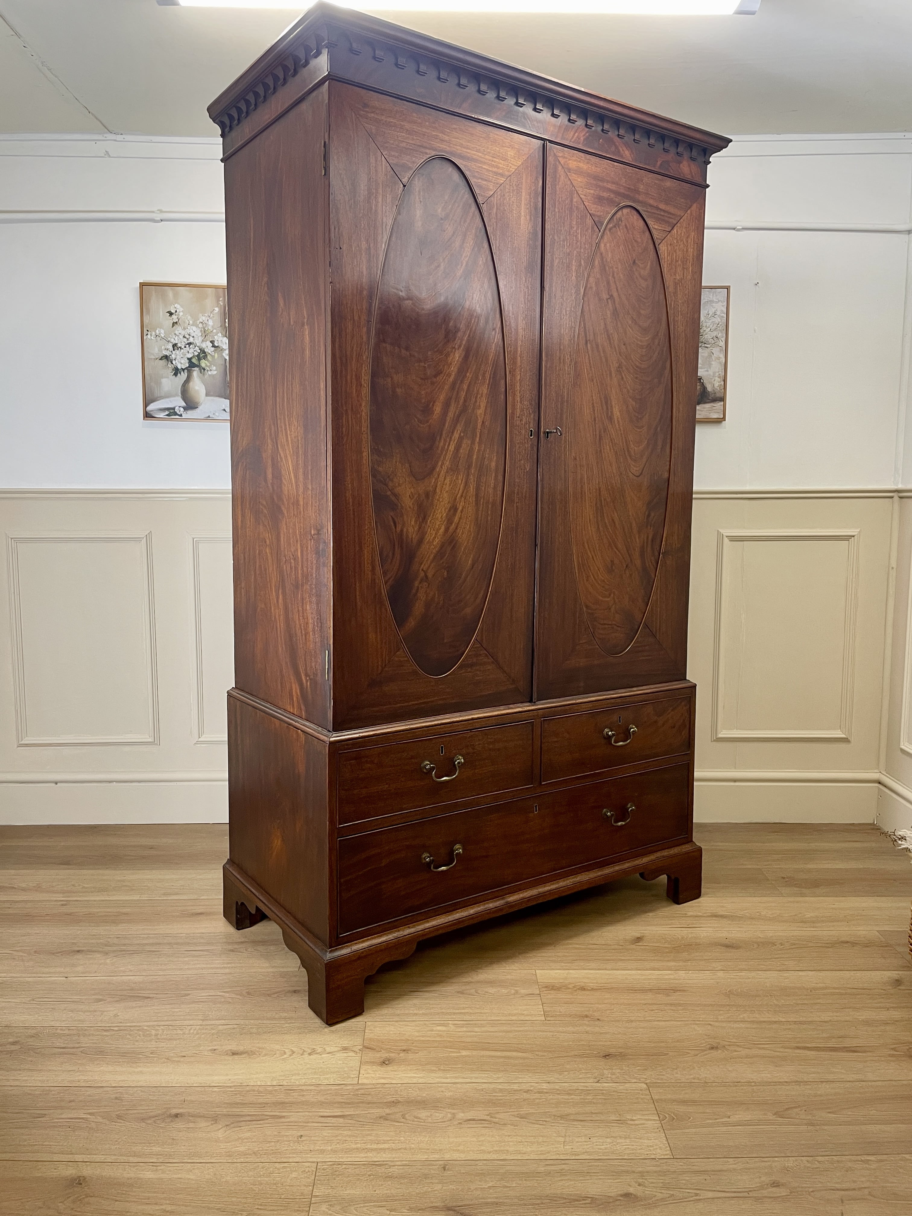 Antique Georgian mahogany tall slim wardrobe with drawers and oval panel doors on ogee bracket feet