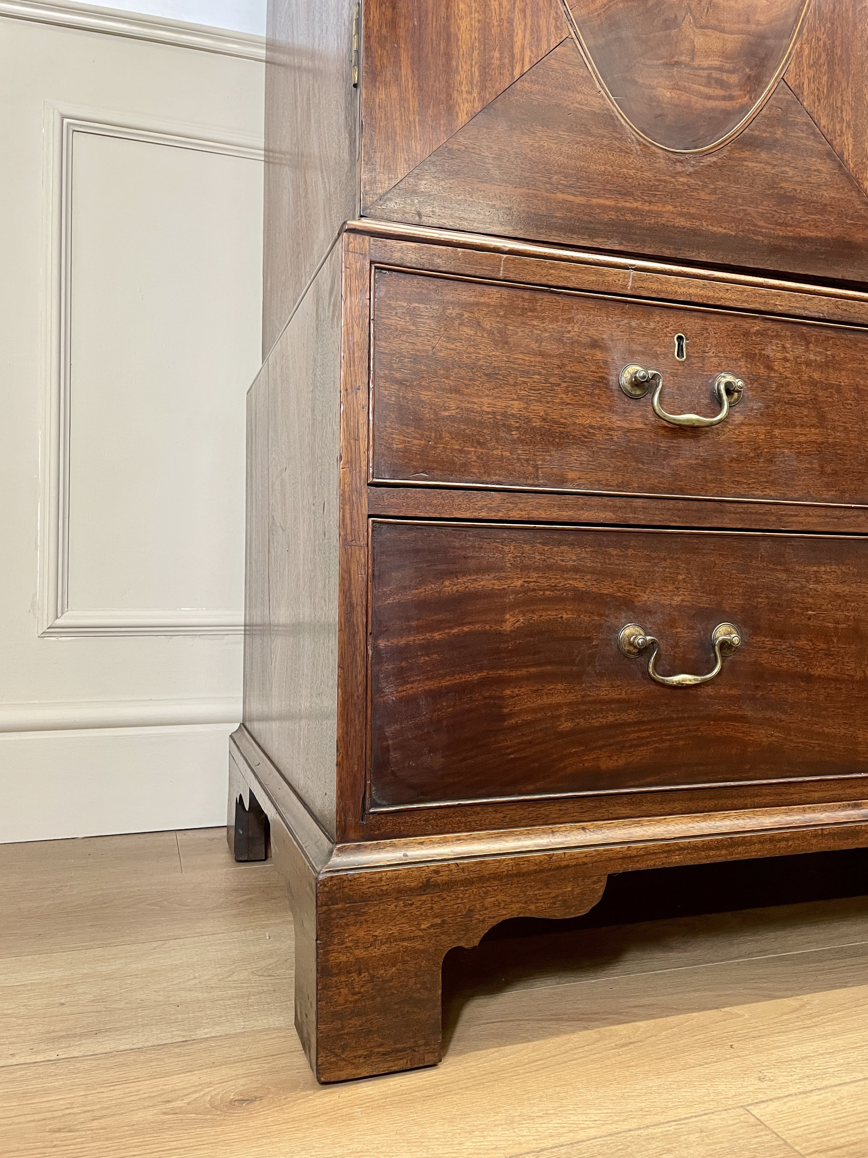 Antique Georgian mahogany tall slim wardrobe with drawers and oval panel doors on ogee bracket feet