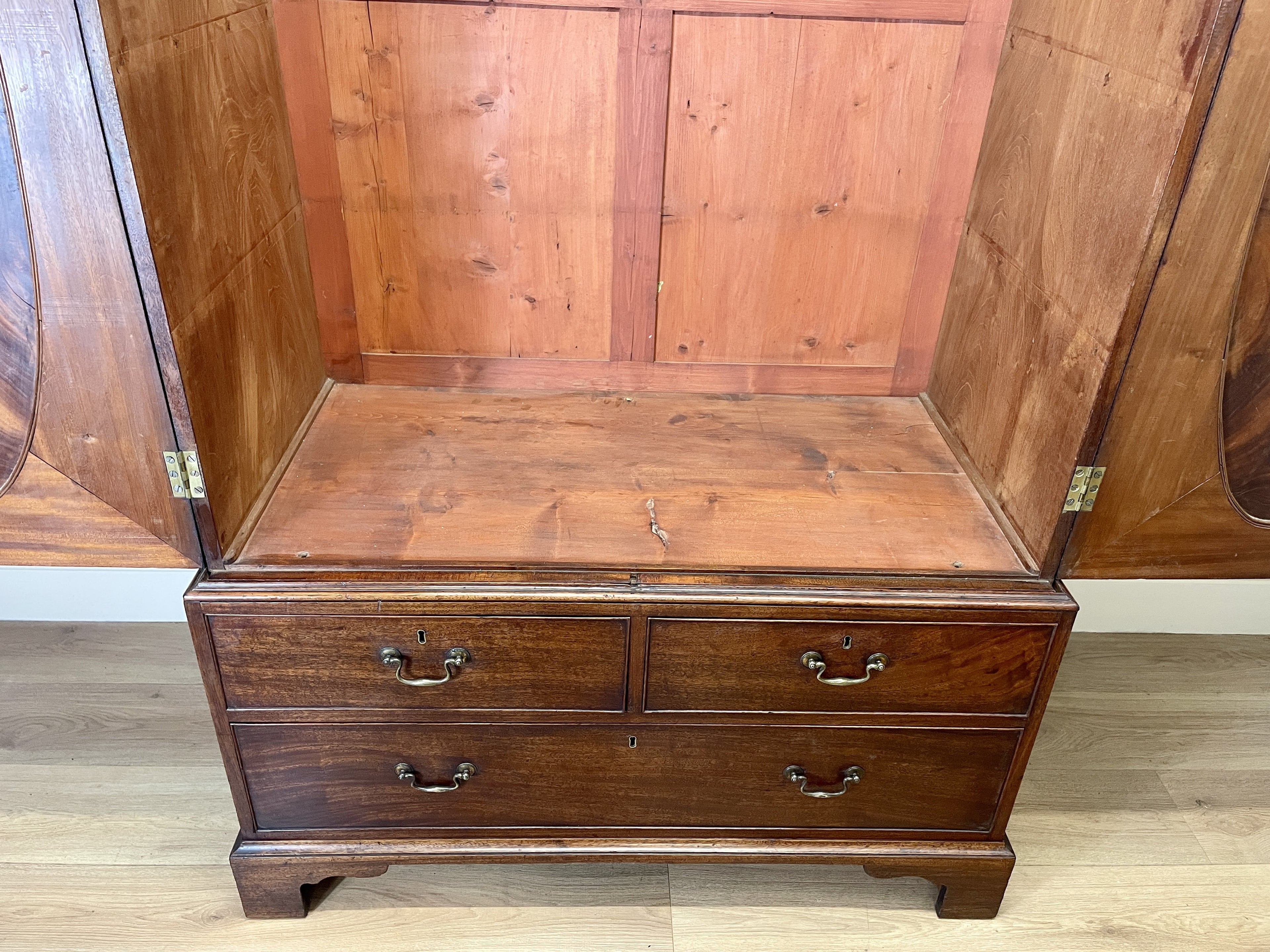 Antique Georgian mahogany tall slim wardrobe with drawers and oval panel doors on ogee bracket feet