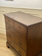 Mid-18th century antique Georgian oak chest of drawers with caddy moulded top, two short and three long graduated drawers, original brass handles, and bracket feet.