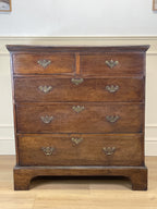 Mid-18th century antique Georgian oak chest of drawers with caddy moulded top, two short and three long graduated drawers, original brass handles, and bracket feet.