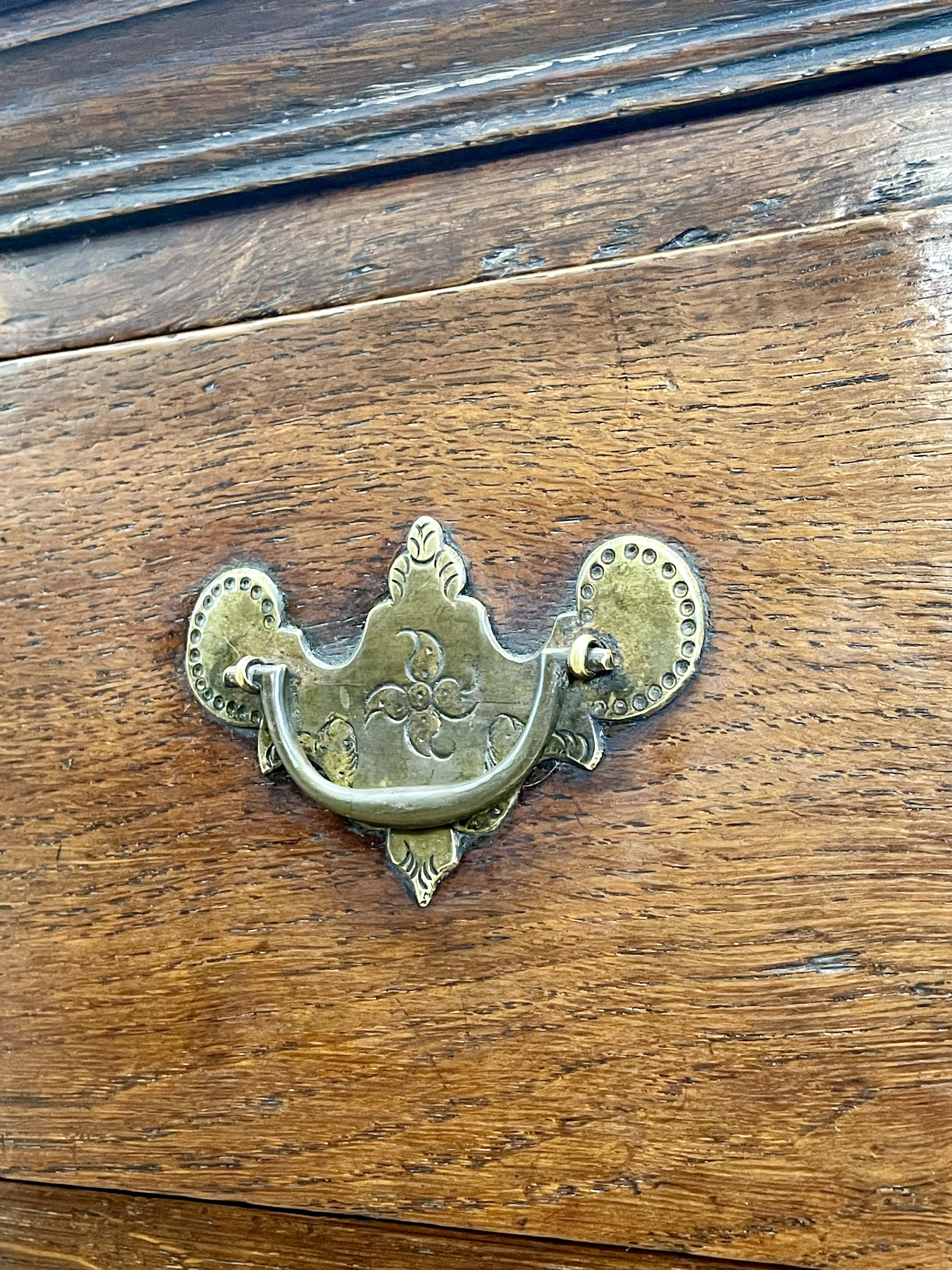 Mid-18th century antique Georgian oak chest of drawers with caddy moulded top, two short and three long graduated drawers, original brass handles, and bracket feet.