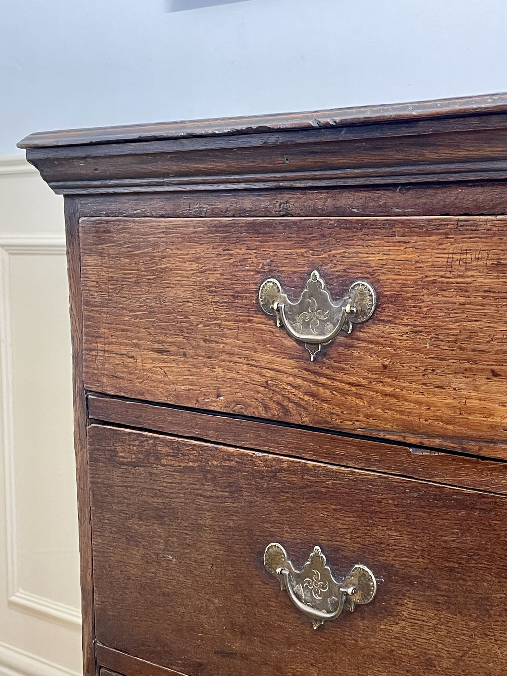 Mid-18th century antique Georgian oak chest of drawers with caddy moulded top, two short and three long graduated drawers, original brass handles, and bracket feet.