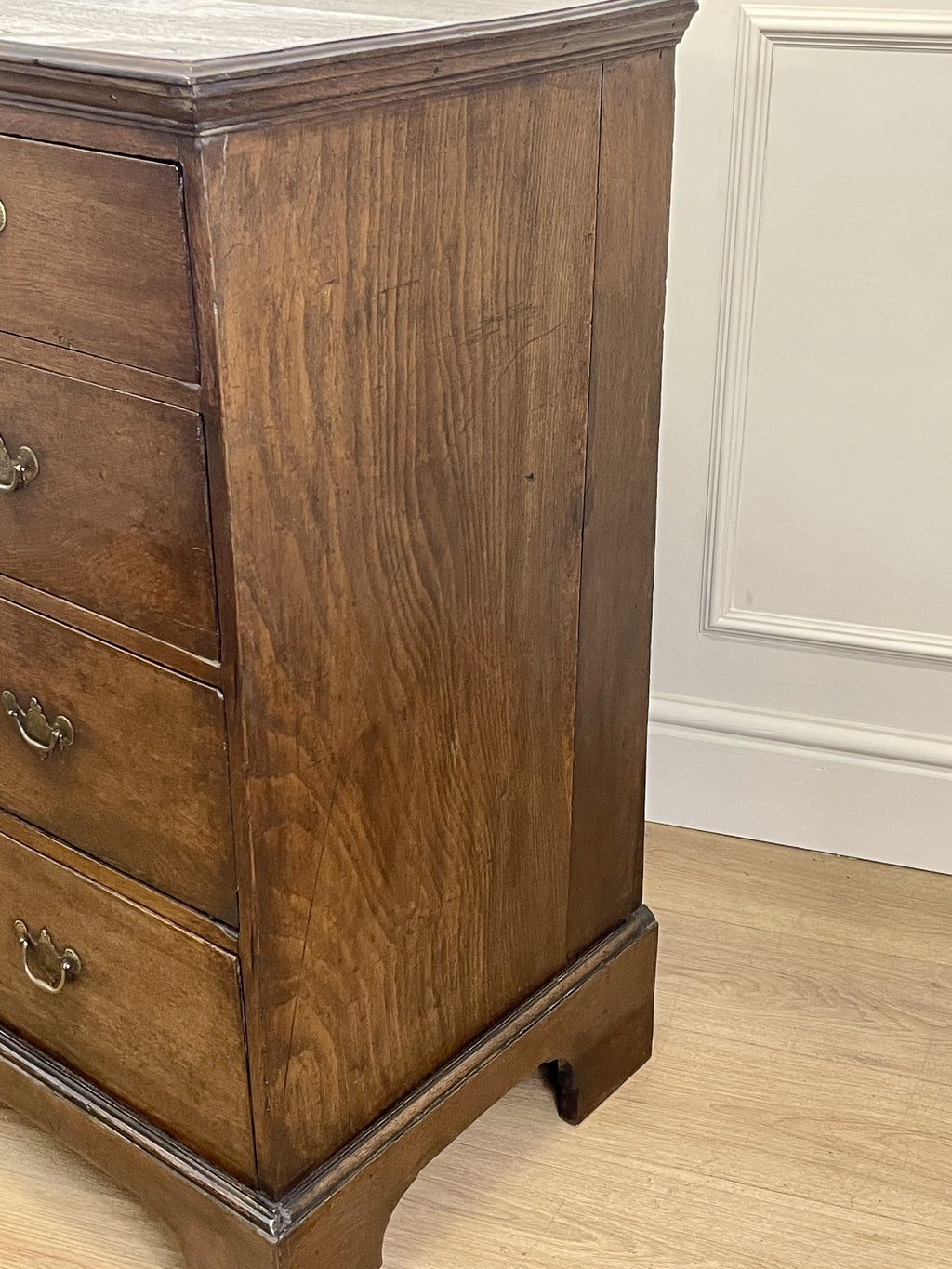 Mid-18th century antique Georgian oak chest of drawers with caddy moulded top, two short and three long graduated drawers, original brass handles, and bracket feet.