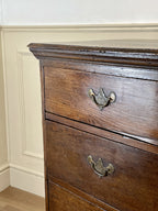 Mid-18th century antique Georgian oak chest of drawers with caddy moulded top, two short and three long graduated drawers, original brass handles, and bracket feet.