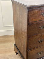 Mid-18th century antique Georgian oak chest of drawers with caddy moulded top, two short and three long graduated drawers, original brass handles, and bracket feet.