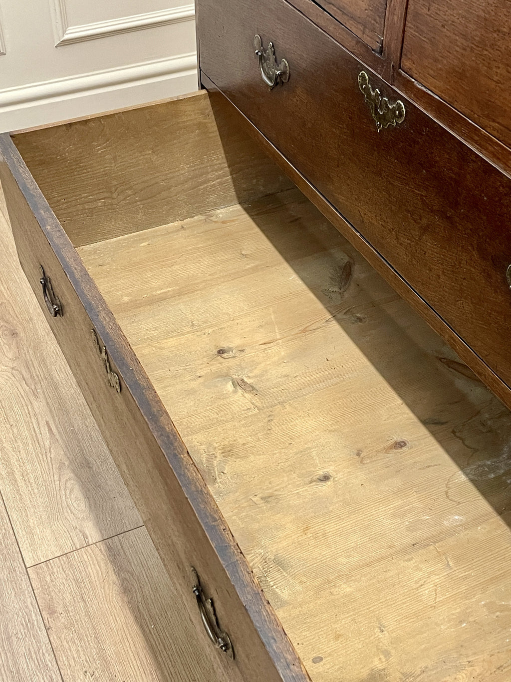Mid-18th century antique Georgian oak chest of drawers with caddy moulded top, two short and three long graduated drawers, original brass handles, and bracket feet.