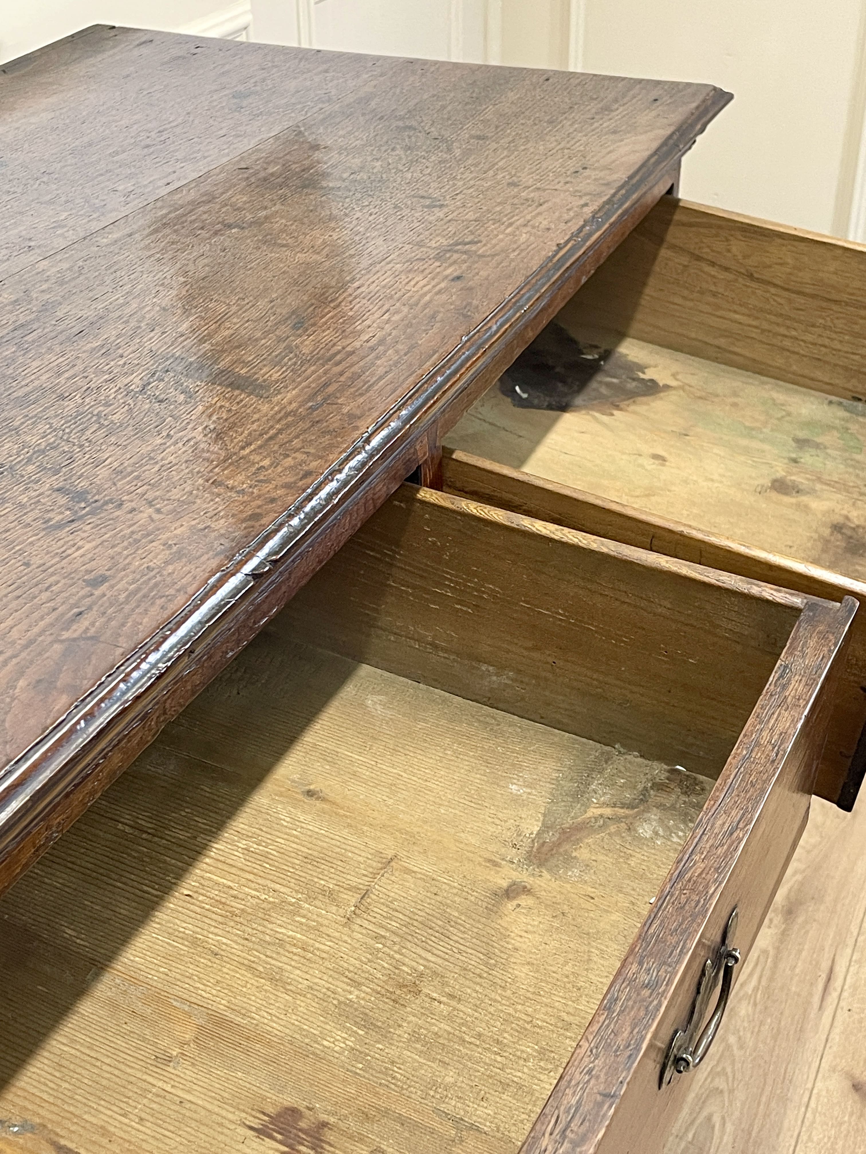 Mid-18th century antique Georgian oak chest of drawers with caddy moulded top, two short and three long graduated drawers, original brass handles, and bracket feet.