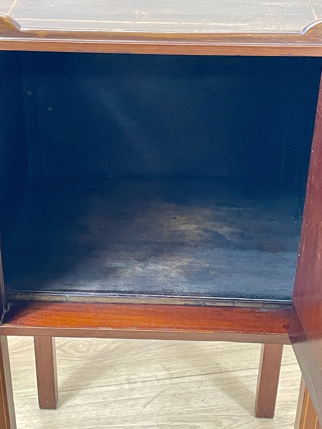 Wooden cabinet with a dark blue interior on a wooden floor