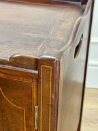 Close-up of a wooden cabinet corner with a visible hinge.