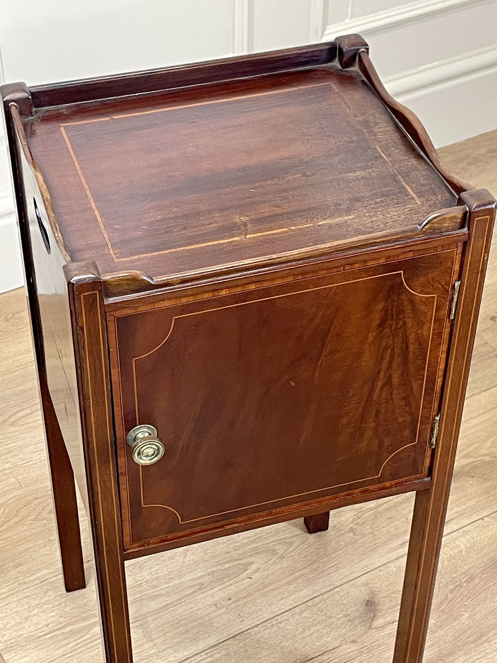 Wooden side table with a cabinet on a wooden floor
