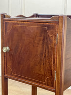 Wooden cabinet with a door and metallic handle on a light wooden floor.