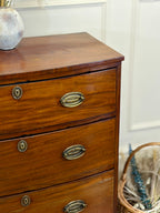 Wooden dresser with brass handles in a room setting