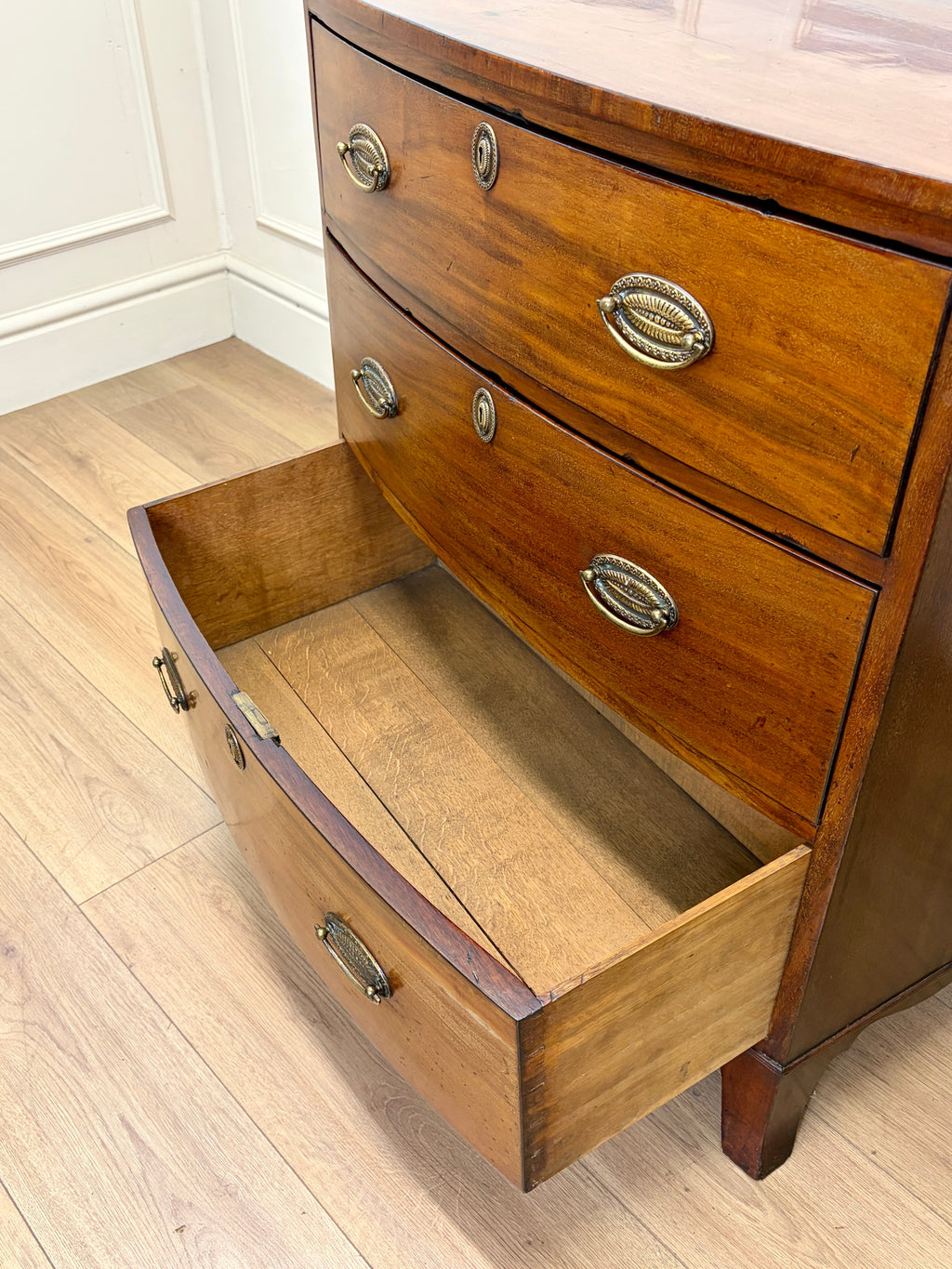 Wooden dresser with open drawer on a wooden floor