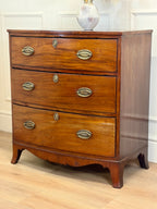 Wooden dresser with four drawers on a wooden floor.