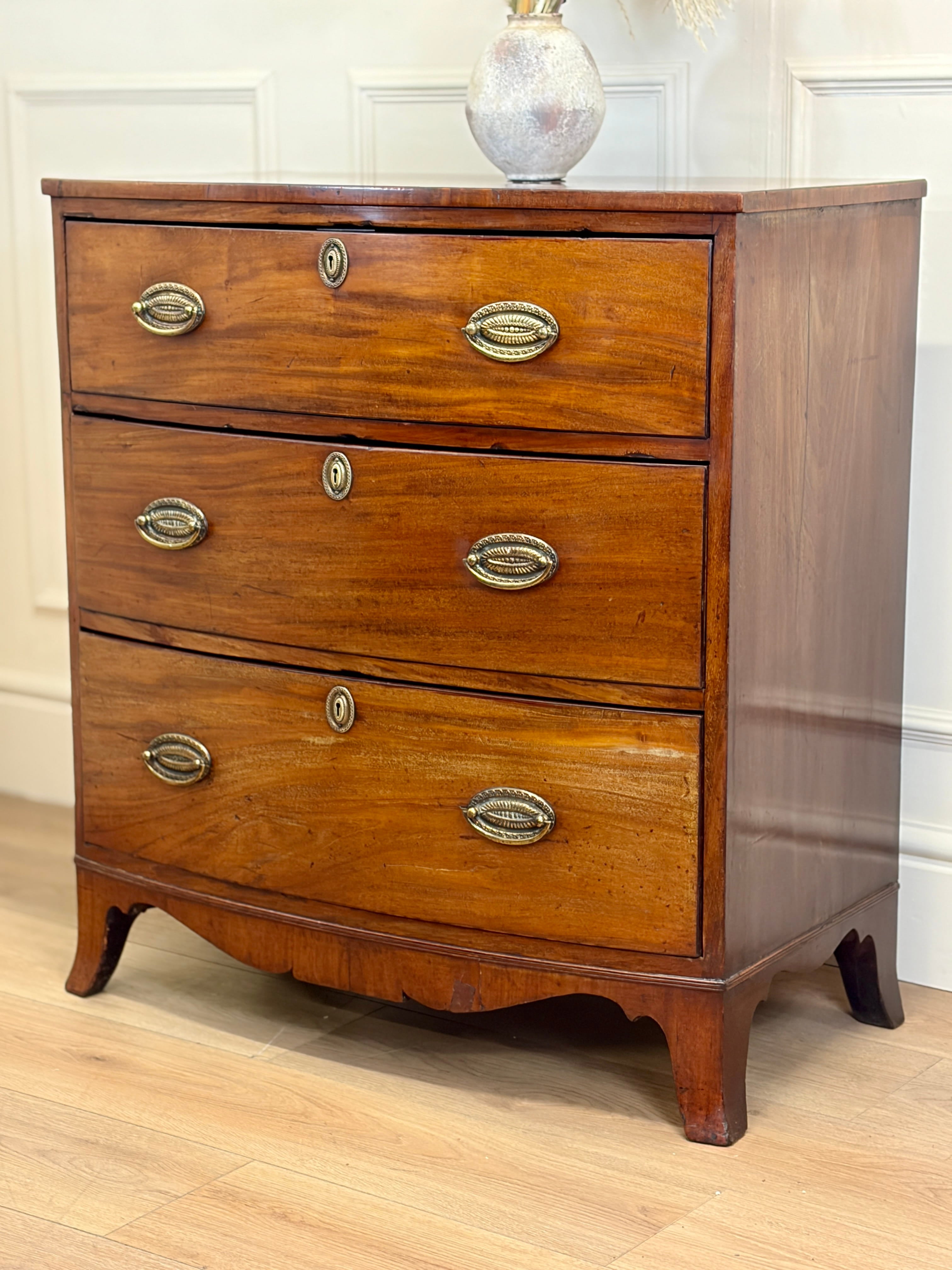 Wooden dresser with four drawers on a wooden floor.