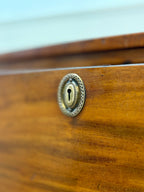 Close-up of a wooden drawer with a brass keyhole