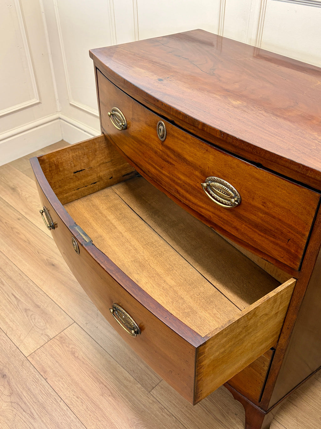 Wooden dresser with open drawer on a wooden floor