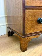 Wooden cabinet with a drawer and handle on a wooden floor.