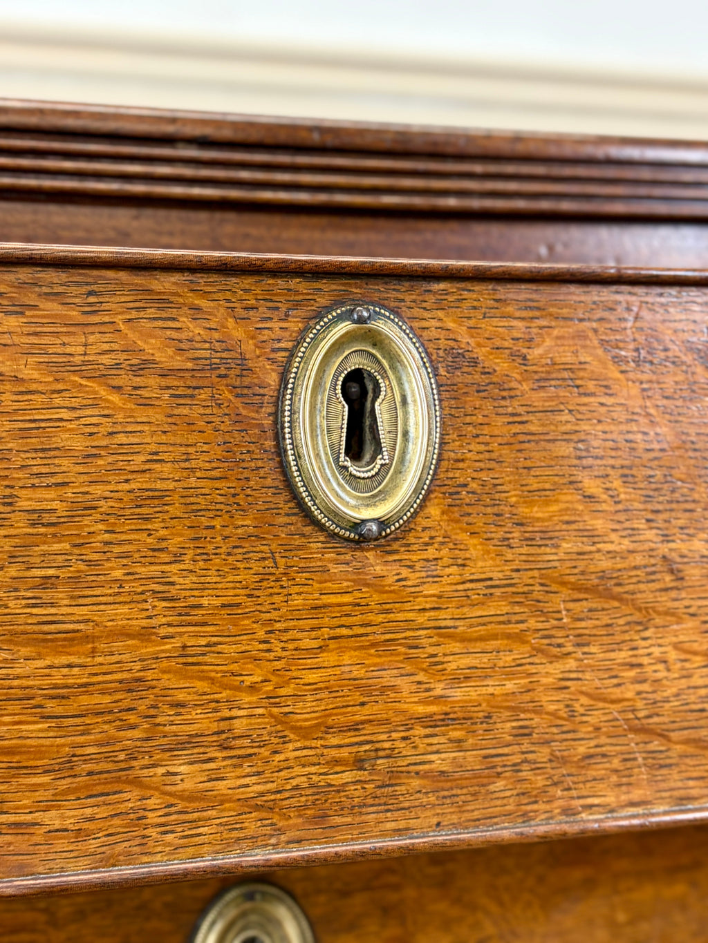 Close-up of a wooden drawer with a brass keyhole