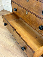 Wooden dresser with open drawer on a wooden floor