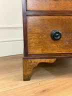 Wooden drawer with a black handle on a wooden floor.