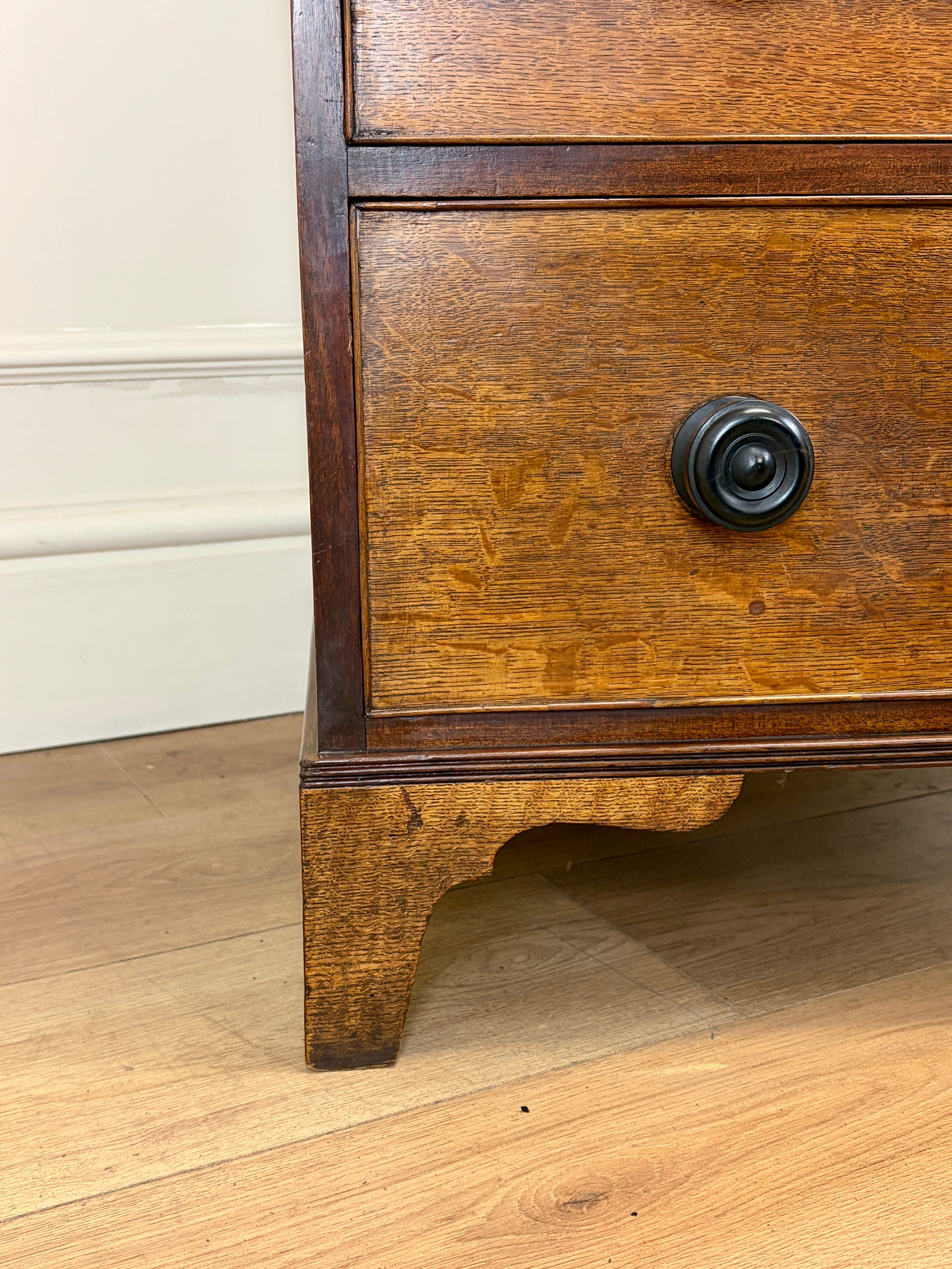 Wooden drawer with a black handle on a wooden floor.