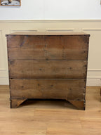 Vintage wooden dresser with chipped paint on a wooden floor.